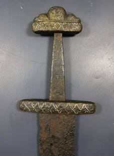 VIKING IRON SWORD WITH SILVER INLAY: Mid-10th century AD. A hand-forged Viking iron sword with three-lobe pommel and decorated guard; the blade is wide at the upper end, gently tapering with fuller to both faces, rounded tip, indented ri