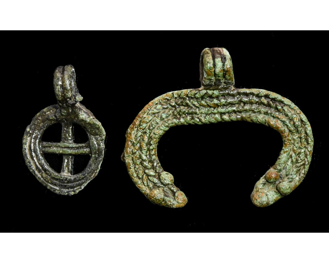 PAIR OF VIKING ASTROLOGICAL PENDANTS: Ca. 900 AD . Pair of wearable Viking Astrological pendants, the larger sized pendant representing a Moon Crescent, the smaller pendant symbolizing the Sun. Good Condition; Wearable; 25-40mm; 0.98x 1.5