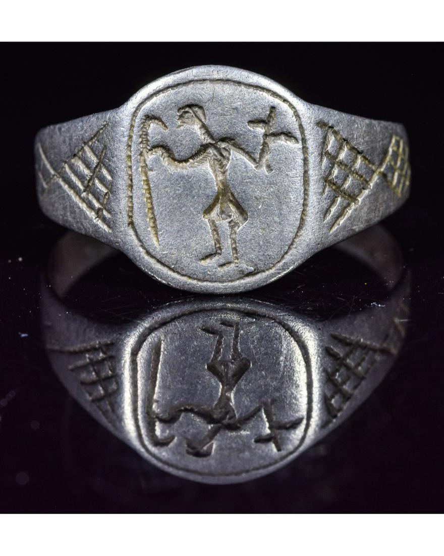 MEDIEVAL SILVER RING DEPICTING WITCH: Ca.1400 AD. Interesting Medieval Silver Ring depicting a witch, recognisable by the bird feet and magical attributes. During the late Medieval period, magic, although illegal, was considered amusing b