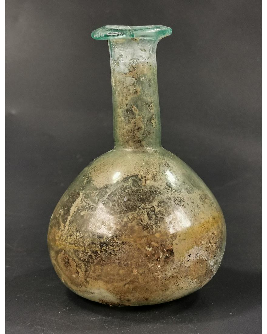 ROMAN UNGUENTARIUM BOTTLE: Ca.100 AD. Ancient Blown Glass bottle with bulbous and tall neck. Beautiful silver iridescent surface patina.Very Good Condition; Intact. Size: H:105x80mm;4.13x 3.15in;70gr; Provenance: Property of a 