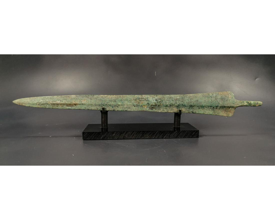 GREEK ARCHAIC PERIOD SWORD BLADE: Ca. 1600 - 1200 BC. Greek Archaic period sword blade. A large and well-formed bronze blade that rises in the center in a very gentle ridge and flattens out at twin sharp edges. A sturdy tang ending in