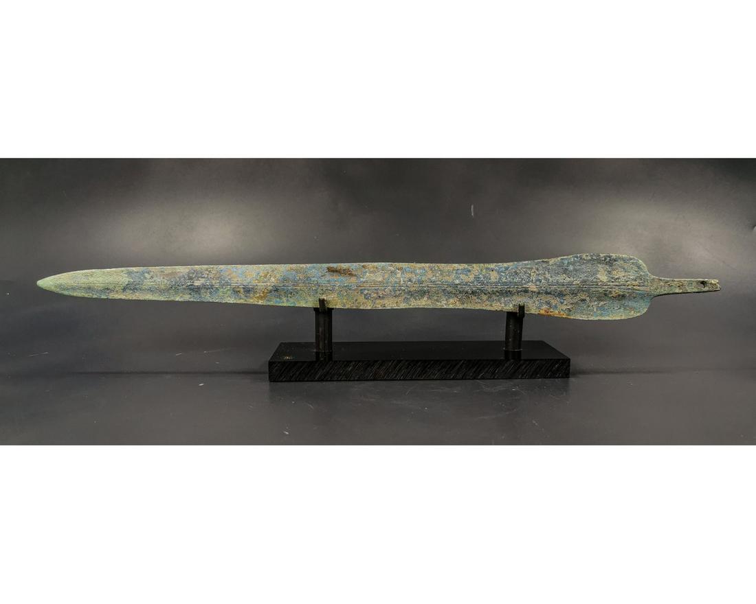 GREEK ARCHAIC PERIOD SWORD BLADE: Ca. 1600 - 1200 BC. Greek Archaic period sword blade. A large and well-formed bronze blade that rises in the center in a very gentle ridge and flattens out at twin sharp edges. A sturdy tang ending in