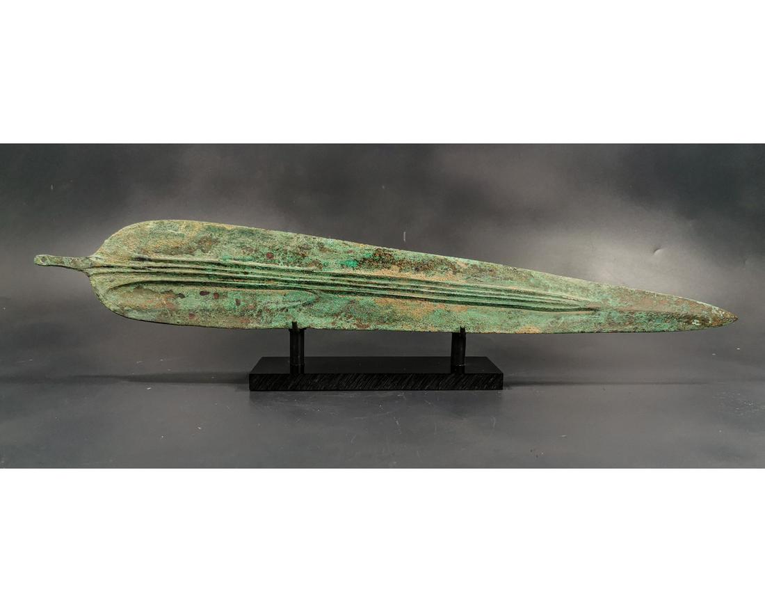 GREEK ARCHAIC PERIOD WIDE SWORD: Ca. 1600 - 1200 BC. Greek Archaic Period wide Sword Blade. A large and well-formed bronze blade that rises in the center in a very gentle ridge and flattens out at twin sharp edges. A wide, sturdy tan