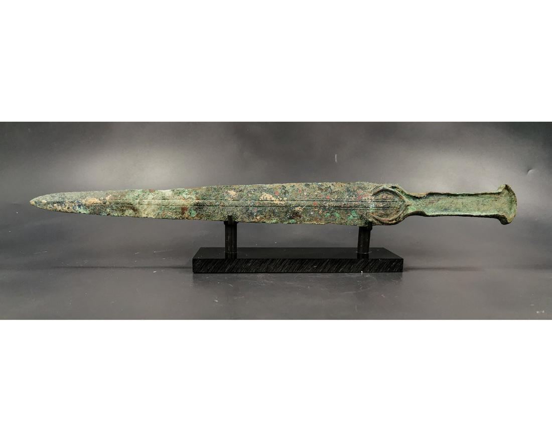 BRONZE AGE SWORD WITH IBEX HANDLE: Ca .1200 BC. Greek Archaic Period Bronze Sword with tapering lentoid-section two-edged blade, crescentic lower guard, Ibex shaped handle designed to have an inlaid bone or ivory panel. Superb Conditio