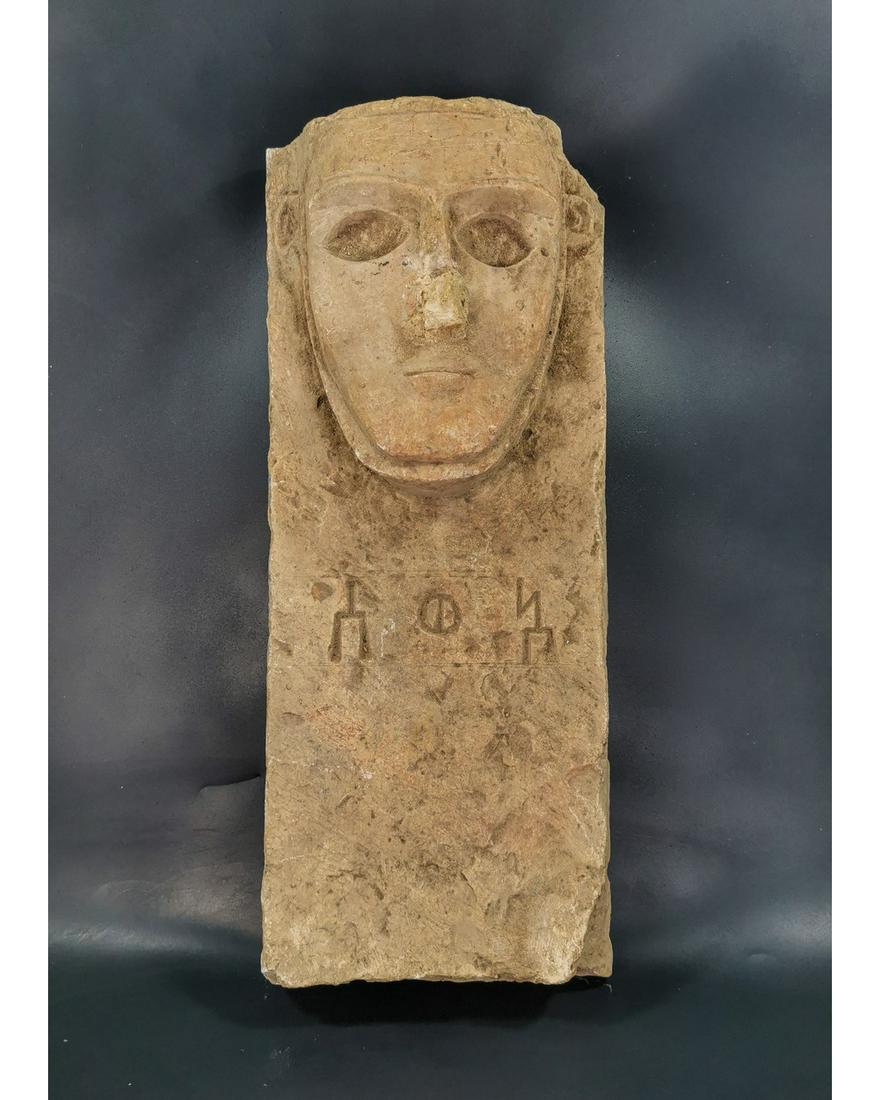 YEMEN ALABASTER FACE STELA: Ca.200 BC - 100 AD. South Arabia, Qatabanian culture, A striking limestone high-relief stela with inscription, a carved abstract face with a triangular nose, deep set oval eyes, a small mouth, promine