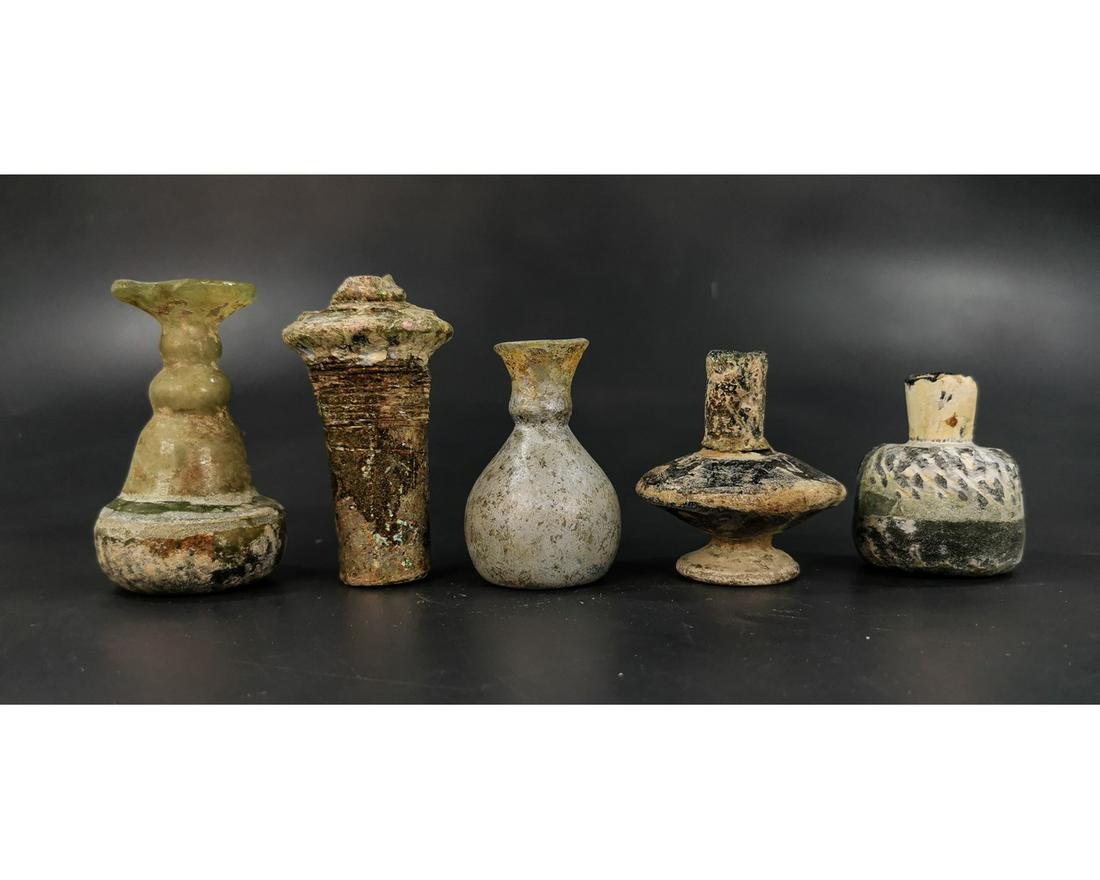 COLLECTION OF ROMAN GLASS BOTTLES: Ca.100-700 AD. Collection of Roman and later period glass vessels in various shapes, sizes and colours. Good Condition; minor repair in some of the vessels; Size: 63-95mm; 2.48-3.74in; 335gr; Provenan