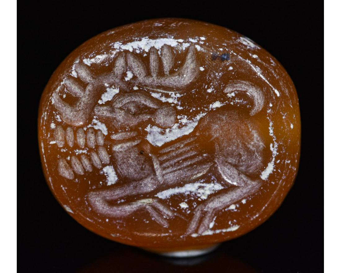 SASSANIAN CARNELIAN STONE SEAL BEAD WITH STAG AND: Ca.500 AD. Sassanian carved carnelian bead seal depicting stag. Good Condition; 15x10mm 0.59x0.39in; 55gr; Provenance: Important London collection of Ancient art; formed in the 1970s then passed by de