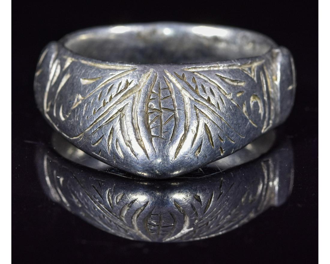SUBSTANTIAL MEDIEVAL SILVER ARCHER'S RING: Ca.1200 AD. An Important wearable Medieval silver archers ring with floral patterns depicted in front part of bezel, made for protection for your knuckle from the bow's string; used by aristocrats dur