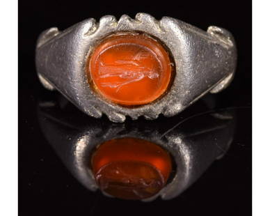 ROMAN SILVER INTAGLIO RING WITH CERES: CA. 200 AD. Superb Ancient Roman silver ring; a well preserved D-shaped hoop forming an elliptical bezel; decorated shoulders; carved red intaglio stone inserted in the middle; depicting the goddess