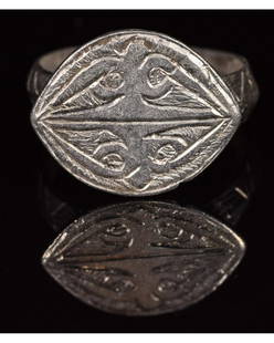 MEDIEVAL SILVER RING WITH RAVEN HEADS: CA. 1000 AD Viking age silver ring; composed of a round-shaped hoop; forming an elliptical bezel; decorated shoulders; the bezel depicts four bird heads, resembling ravens; possibly representing