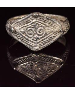 VIKING SILVER RING WITH RUNIC SYMBOL: CA. 900 AD Rare Viking period silver ring; composed of an oval-shaped hoop, forming a large bezel; elaborately decorated with a geometric pattern on the border; central part depicting an interesting