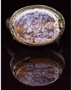 BYZANTINE SILVER RING WITH GEM: CA. 800 AD Interesting Medieval silver ring; composed of a round-shaped hoop; applied elliptical bezel with large inserted gem; elaborately decorated rim; Very good, wearable condition;