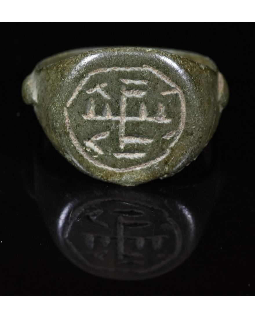 MEDIEVAL BRONZE RING WITH CHRISTIAN MONOGRAM: Ca.1100-1400 AD A interesting Crusaders Era bronze ring with a Christian monogram on the bezel; intact oval shaped band. Possibly worn by a knight in the holy lands. Good Condition; wearable; D:19mm/L
