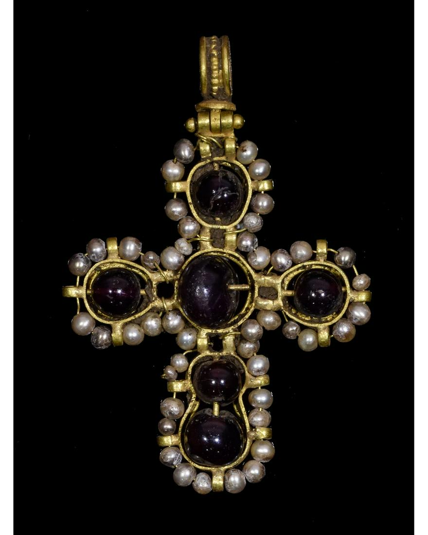 BYZANTINE GOLD CROSS WITH STONES AND PEARLS: Ca.900 AD. A delicate polychrome cruciform pendant formed from five discoid elements, comprising: the head and arms each a gold collet enclosing a pierced garnet set on a rod, surrounded by a fine wir