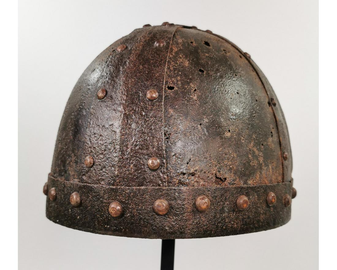 RARE VIKING IRON HELMET: Ca. 900 - 1000 AD. A helmet fabricated from four triangular iron plates curved to conform to the human head; riveted construction; with bands inside and outside supporting the structure of the helmet;