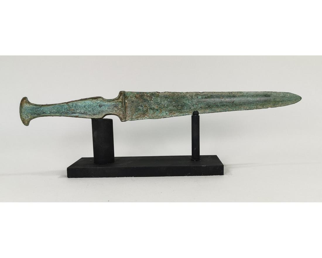 ANCIENT BRONZE SWORD WITH HANDLE: Ca. 800 BC. A Greek Archaic Period sword with intact handle. A fine example of a lost wax cast bronze sword with a narrow handle designed to have an inlaid bone or ivory panel. Blade with geometric pa
