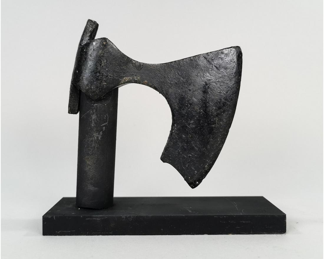 VIKING BEARDED AXEHEAD ON STAND: Ca. 900 - 1100 AD. An iron Viking Bearded axehead with a slender curved blade with reinforced cutting edge and chin to the lower edge, round socket with triangular flanges and long rectangular panel t