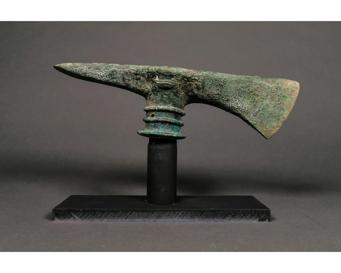 DECORATED BRONZE AGE BATTLE AXE: Ca. 1200- 800 BC. Superb Bronze Age Western Asiatic battle axe; combined in ax-adze with circular shaft hole; the transverse blade trapezoid with expanding cutting edge; the axial blade expanded with 