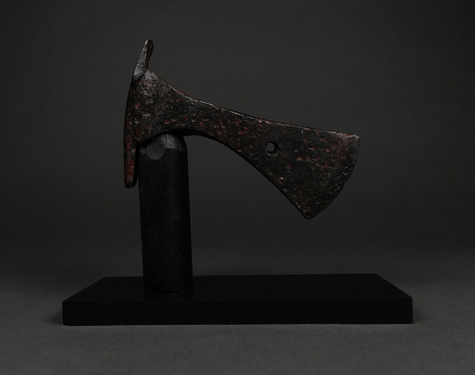 VIKING IRON BATTLE AXE ON STAND: c. 900-1100 AD. Viking age. This iron battle axe features a circular sokcket and a long, narrow head, allowing its user to deliver maximal force in a single, precision blow. A circular aperture in the