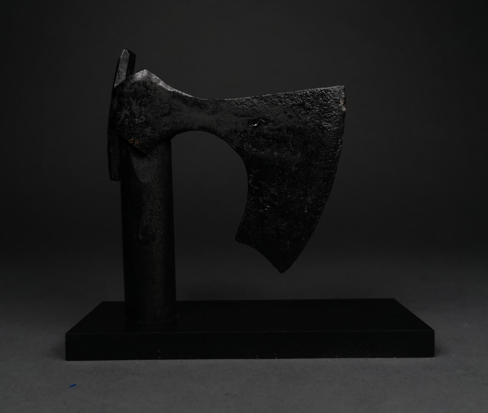 FANTASTIC VIKING BEARDED IRON AXE HEAD: c. 900-1100 AD. Viking Age. An iron bearded axe head with a heavy curved blade, a round socket and rectangular flanges. The item is mounted on a custom-made stand. The bearded axe, or Skeggøx (from O
