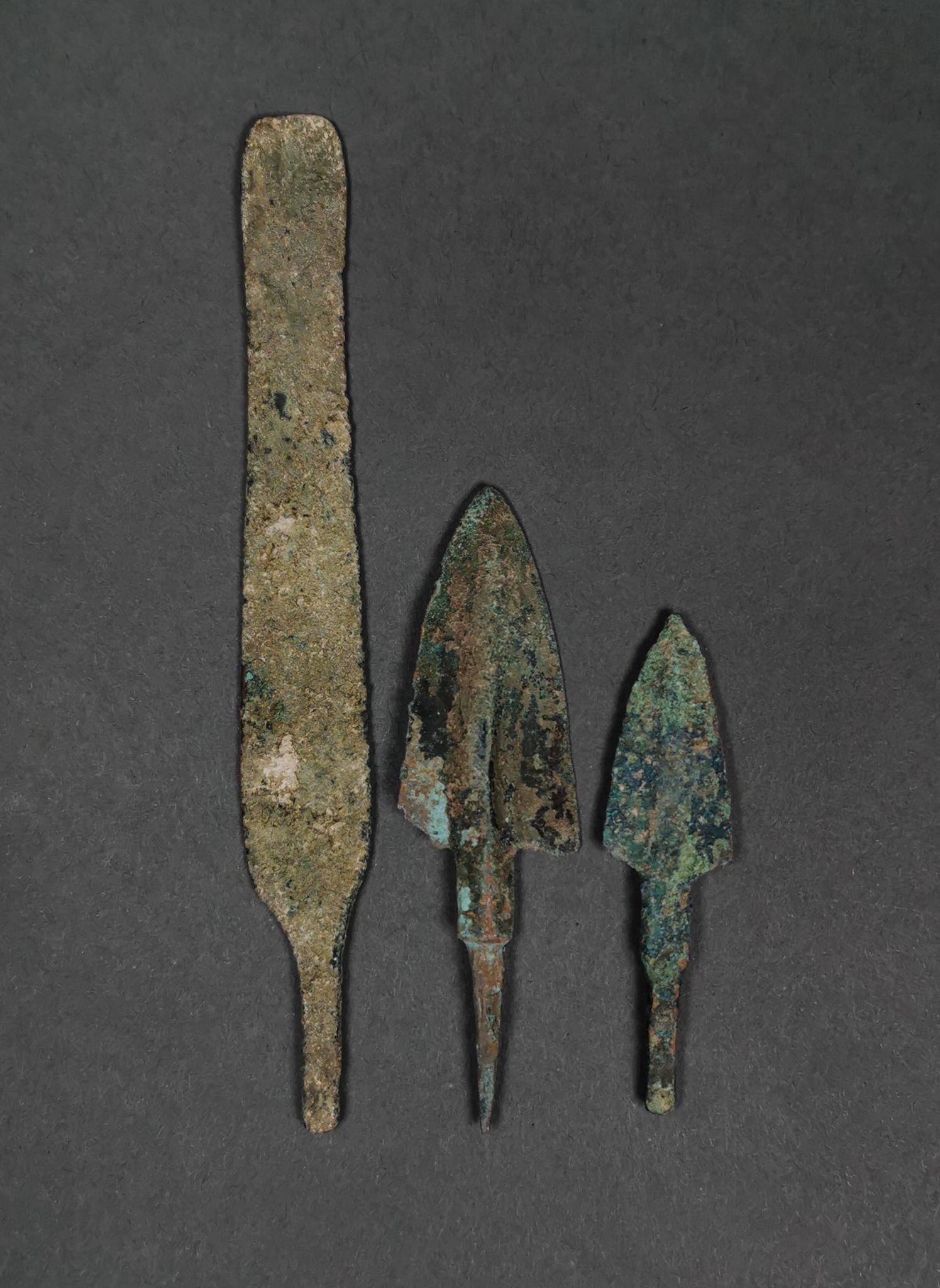 ANCIENT GREEK BRONZE SPEARS (2) AND BLADE (1): 1200 – 800 BC. Greek Archaic period. Lot of a bronze blade and two ancient bronze spearheads; 1) rectangular bronze blade with tang, point missing; 2-3) two spearheads with triangular-shaped, lentoi