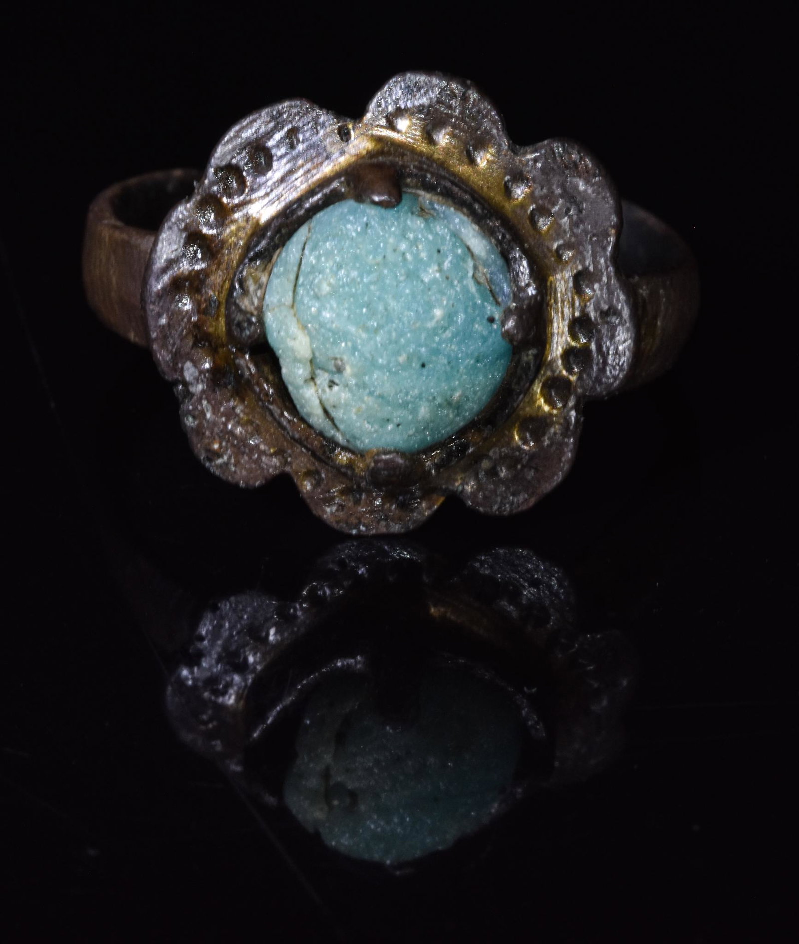BYZANTINE BRONZE RING WITH GEM: 800-1200 AD, Byzantine. Bronze ring with a circular loop, an eight-petalled flower-shaped and light blue glass inset. The medieval empire of Byzantium was justly famous for the elegance of its jewelle