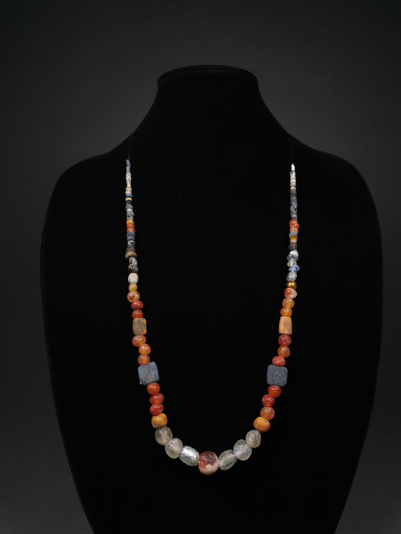 ROMAN BEADED NECKLACE - SUPERB: Ca.1-300 AD. A superb Roman restrung necklace comprising multiple glass and semi-precious stone beads (including a large number of Carnelian examples) in various shapes (e.g. spherical, rectangular an