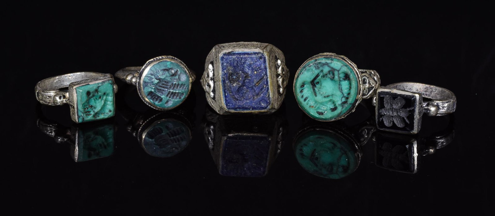 COLLECTION OF TRIBAL RINGS (5): Ca.1700-1950 AD, Yemeni Tribal. Lot of five white metal Yemeni Tribal intaglio rings with turquoise, blue, and black coloured stone settings. Yemeni tribal rings were made by Jewish silversmiths betwe