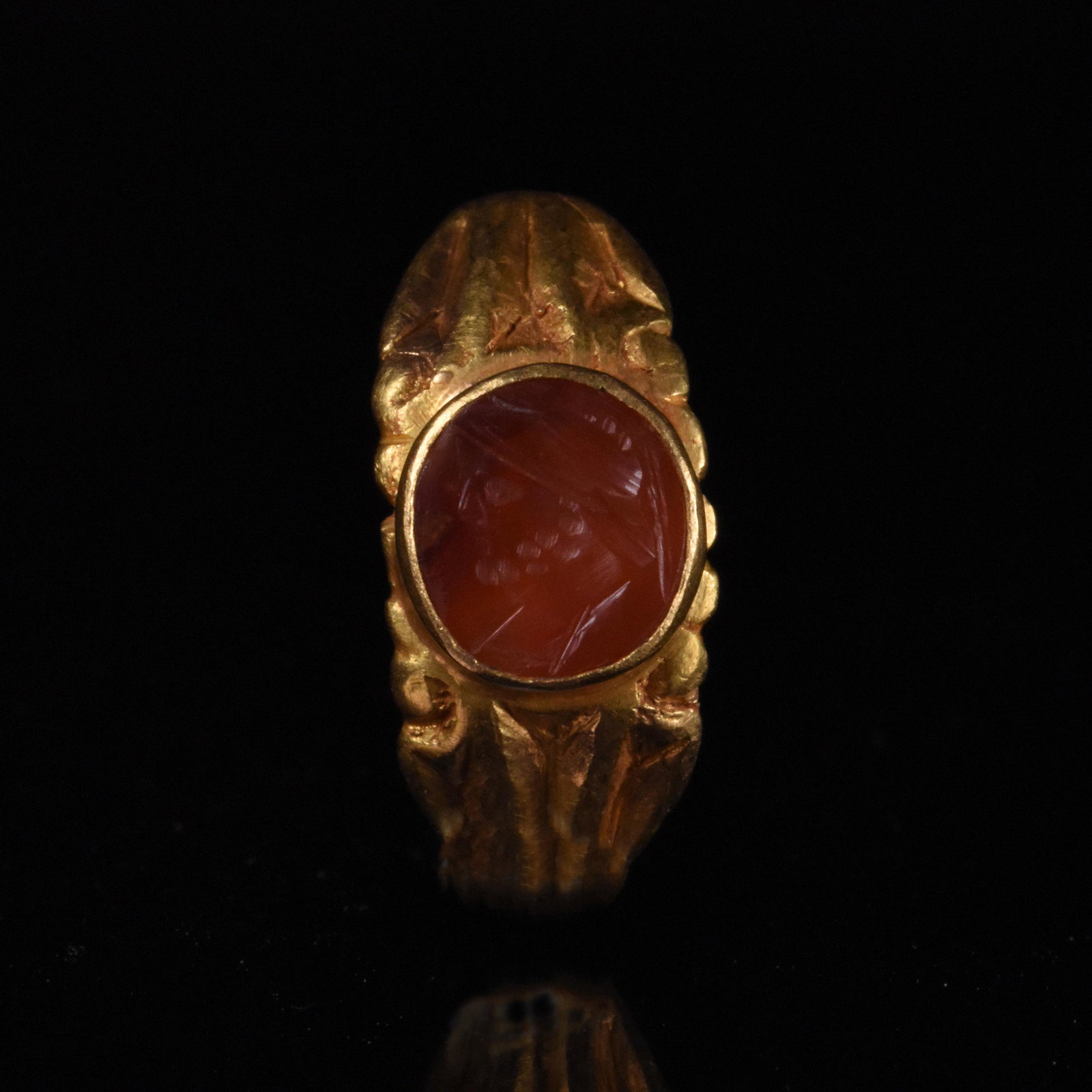 ROMAN GOLD INTAGLIO RING WITH GOD MARS: Ca.100 AD, Roman Amazing intact intaglio gold ring comprising diamond-shaped hoop with crimped decoration and raised bezel with red stone intaglio (probably carnelian), depicting the helmeted god Mars
