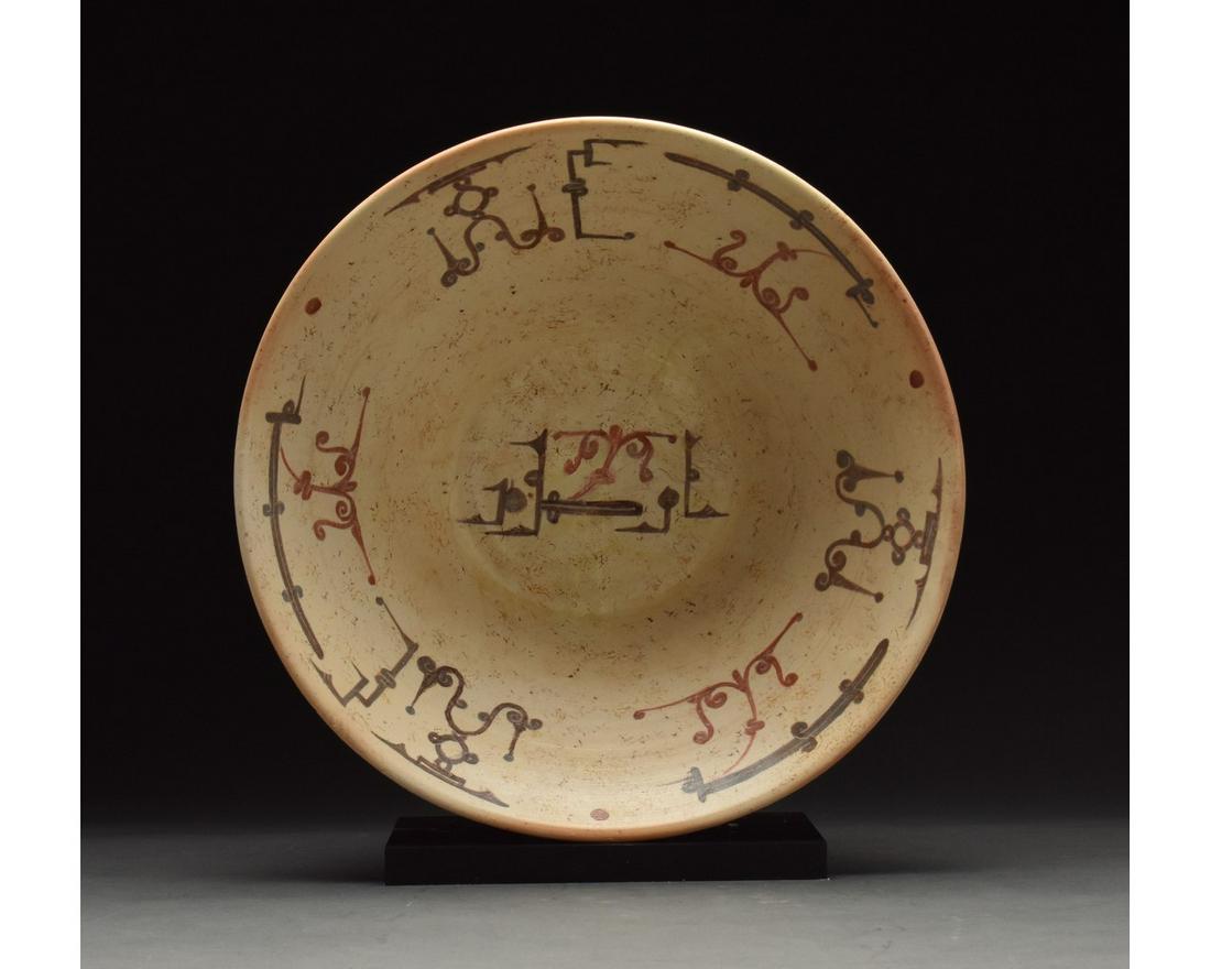 MEDIEVAL ISLAMIC TERRACOTTA PLATE WITH GEOMETRIC: 901 - 1000 AD or later. Medieval Islamic terracotta plate or bowl in a light brown fabric with a cream glazed interior. Brown/black and red geometric decoration ornaments appear in the interior of the