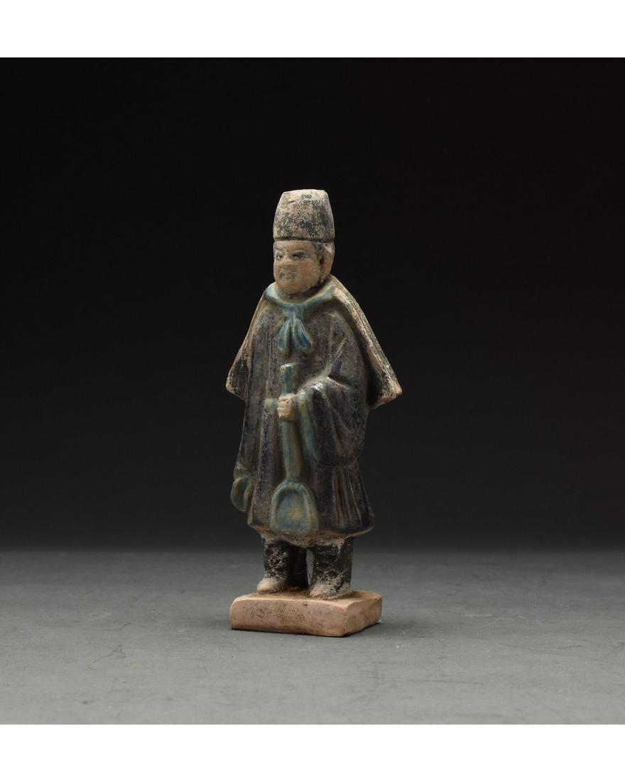 CHINESE MING DYNASTY GLAZED ATTENDANT FIGURE: Ca. 1368-1644 AD. Chinese Ming Dynasty Attendant Figure. An elaborately crafted male attendant figure dressed in a deep blue tunic with vibrant bright blue cuffs, a pleated half-cloak, which is tied a