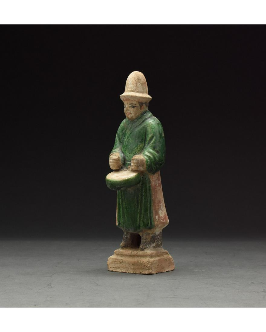 CHINESE MING DYNASTY GLAZED ATTENDANT FIGURE: Ca. 1368-1644 AD. Chinese Ming Dynasty Attendant Figure. An elaborately crafted male attendant figure dressed in emerald green tunic trimmed in red which belted with an orangish sash, and a tall light