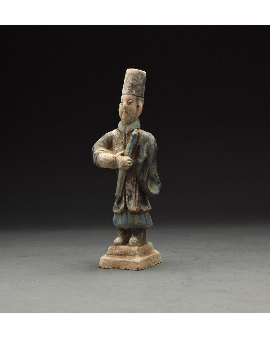 CHINESE MING DYNASTY GLAZED ATTENDANT FIGURE: Ca. 1368-1644 AD. Chinese Ming Dynasty Attendant Figure. An elaborately crafted male attendant figure dressed in a light blue tunic, a dark blue overtunic which is belted with a light blue sash, and a