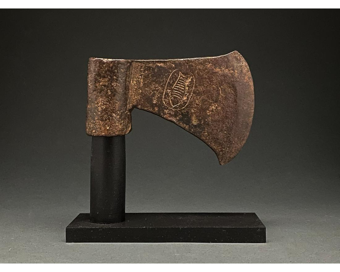 MIGRATION PERIOD IRON BATTLE AXE WITH FISH PATTERN: C. 600 AD. Migration Period. A large iron axe featuring a broad blade with a slightly hooked bottom, flaring head, and long, circular eye. The blade features incised decoration depicting a fish within