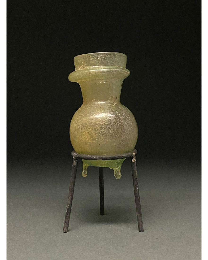 ROMAN GLASS JAR: 1-300 AD Roman. A beautiful light green jar comprising a globular body, a short flaring neck with double outurned rims, and three delicate pinched feet . Glass was a major manufacturing industry in th