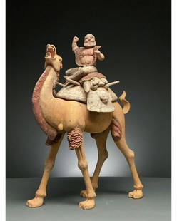 CHINA, TANG DYNASTY POTTERY BACTRIAN CAMEL AND RIDER -: C. AD 618-907. Tang Dynasty. A large ceramic figurine of a Bactrian camel, also known as a Mongolian camel, with a rider. The beast features a sandy pelt, while its characteristic mane, beard and the