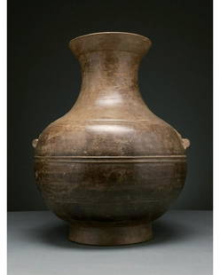 CHINA, HAN DYNASTY LARGE POTTERY VESSEL WITH TAOTIE: Ca. 206 BC-220 AD. Han Dynasty. Beautiful ceramic vase with a beige fabric and glossy brown slip. The vase comprises a flaring rim, elongated neck and a round globular body supported by a cylindrical