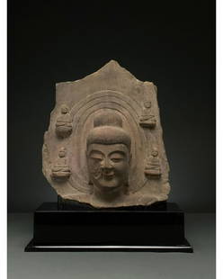 CHINA, MING DYNASTY STONE BUDDHA HEAD WITH HALO: C. 1368-1644. Ming Dynasty. Greyish-brown stone head of Buddha in high relief with a three-rowed halo. Buddha is depicted with an elaborate high topknot (Ushnisha), abstract stylised features