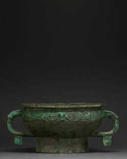 CHINA, EARY WESTERN ZHOU DYNASTY BRONZE RITUAL GUI: 1100-900 BC. Early Western Zhou Dynasty. Bronze cast vessel Gui comprising a broad shelf-like lip, hemispherical bowl, wide loop handles topped with moulded dragons, and a cylindrical base. Just