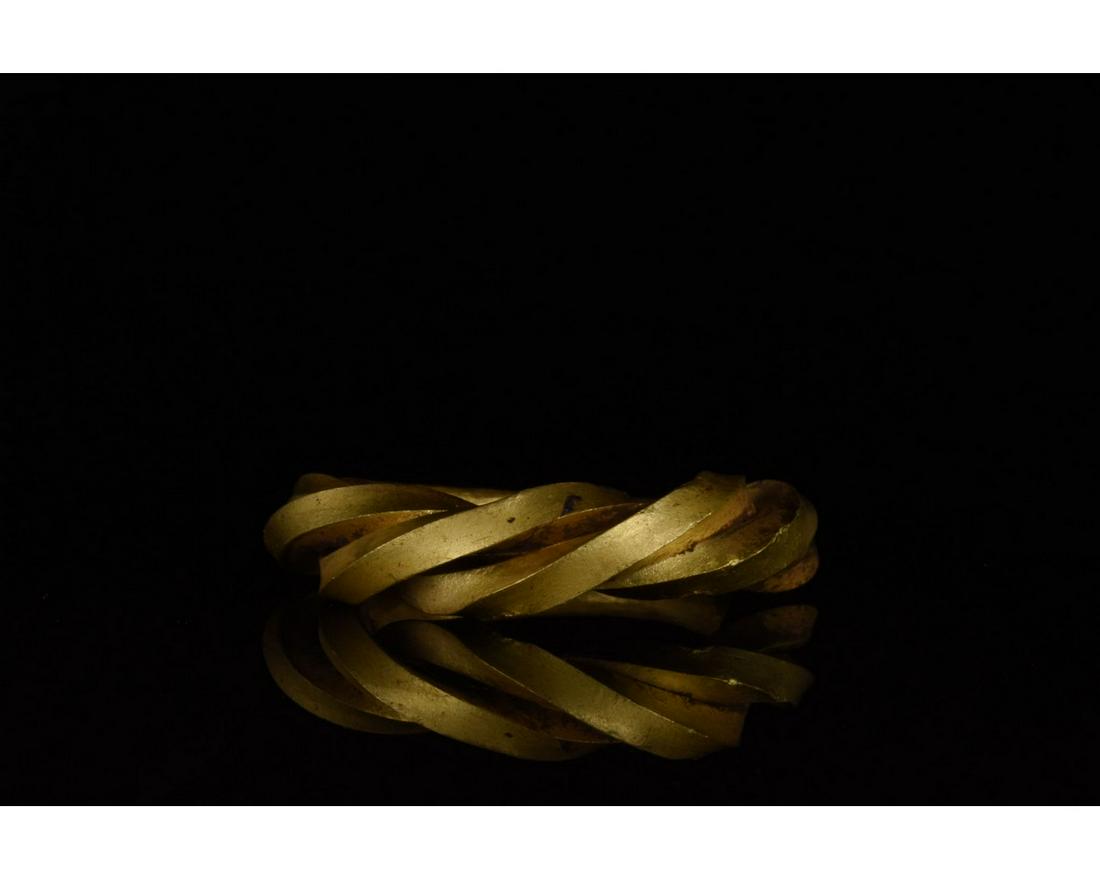 VIKING GOLD TWISTED RING - XRF TESTED: c. 900-1100 AD. Viking Age. Twisted gold ring comprising of circular hoop separating at the shoulders into three, interwoven strands. This ring was intended to evoke the form of a snake. In Norse myth