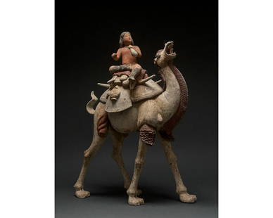 MAGNIFICENT CHINESE TANG DYNASTY BACTRIAN CAMEL - TL: C. AD 618-907. Tang Dynasty. A large ceramic figurine of a Bactrian camel, also known as a Mongolian camel, with a rider. The beast features a sandy pelt, while its characteristic mane, beard and the