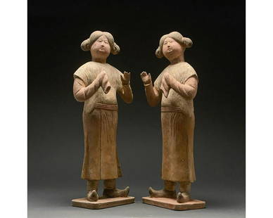 PAIR OF CHINESE TANG DYNASTY COURT ATTENDANTS - TL: C. AD 618-907. Tang Dynasty. Two full-figured court attendant terracottas. Both of these court attendant ladies are posed with both hands held up in front of the torso, one bare and one covered by a