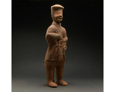 CHINA, HAN DYNASTY POTTERY ATTENDANT FIGURE - TL TESTED: Ca. 206 BCâ€“220 AD, Chinese Han Dynasty. Interesting ceramic figurine of a servant wearing a short tunic, tight trousers, an elaborate hat and tall boots The figurine appears to hold a dish in