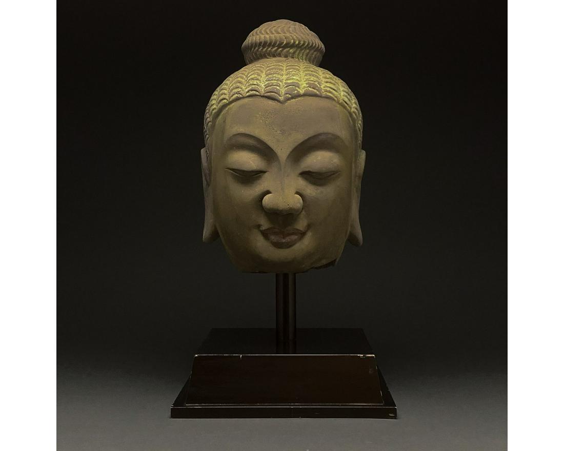 LARGE MING / QING CHINESE POTTERY HEAD OF BUDDHA: 1368-1850. Ming or Qing dynasty. A pottery head of Buddha in a taupe fabric with a yellow painted topknot (ushnisha), arched brow, heavily lidded, closed eyes, a bulbous nose, full, red lips, rounded 