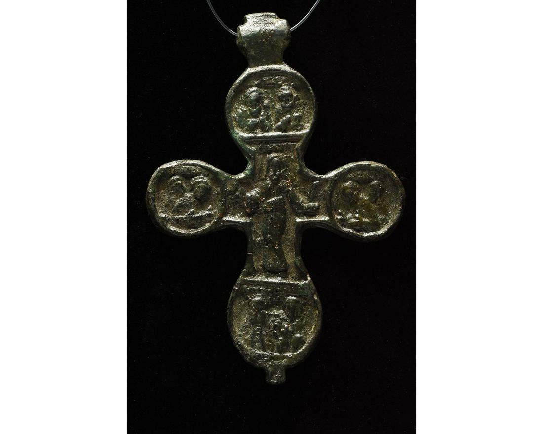 LARGE MEDIEVAL BRONZE CROSS PENDANT: 1000-1500 AD, Crusader Period. A large bronze cross pendant with suspension loop and rounded arms; the cross bears extensive relief decoration on both sides, with Christ standing at the centre on one 