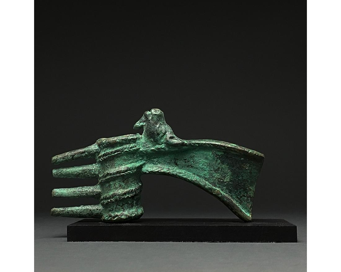 RARE BRONZE AGE SPIKED AXE WITH ANIMAL: C. 2000-700 BC, Luristan culture. A Luristan axe head with a short, curved, downwards facing blade, arched cheek, reinforced rounded poll with four spikes on the reverse which is fashioned into the sh
