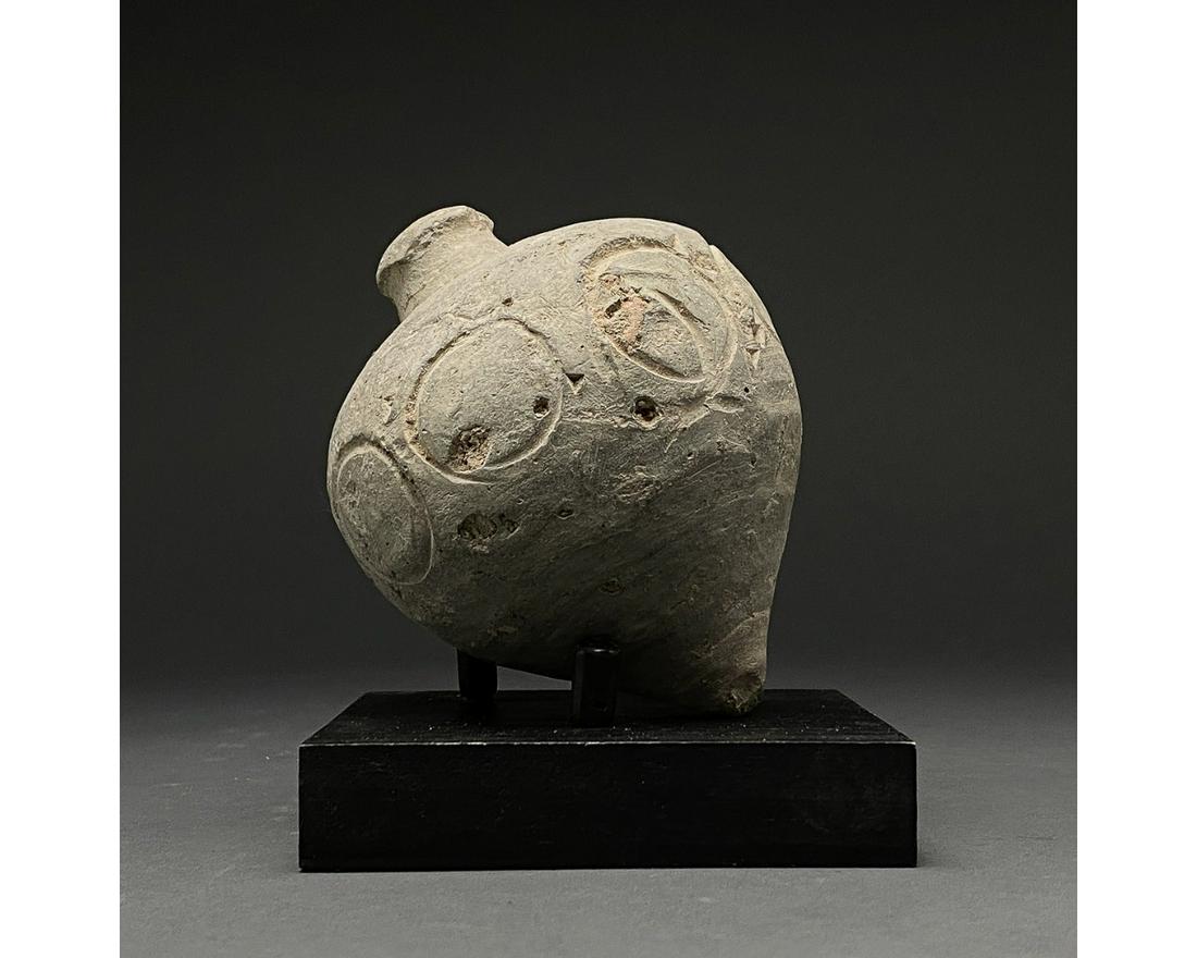 BYZANTINE "GREEK FIRE" POTTERY GRENADE: 900-1200 AD, Byzantine. Decorated Byzantine "fire grenade" comprising a globular greyish vessel with a short neck, flaring shoulders decorated with impressed circle motifs, and a pointed base. Globula