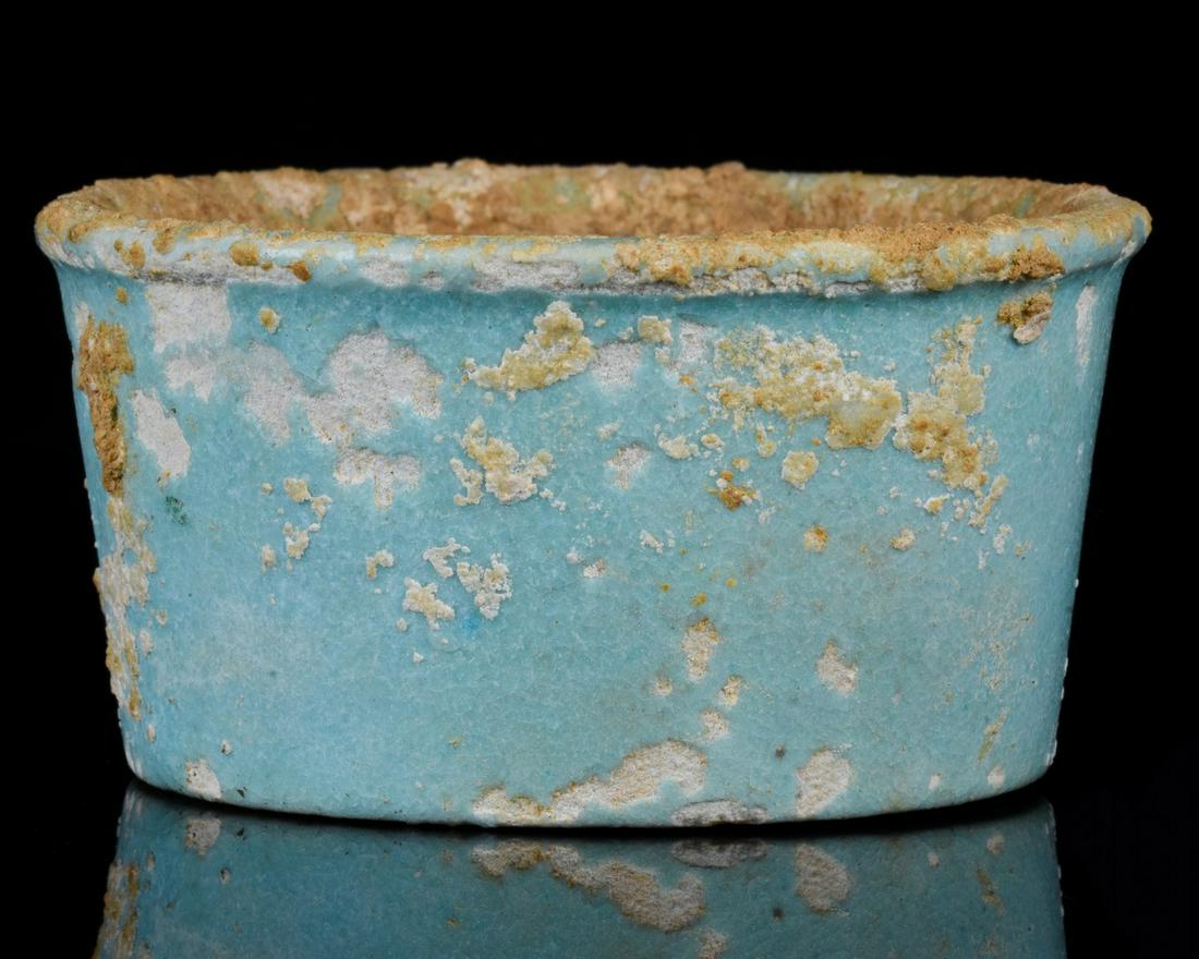 ANCIENT EGYPTIAN FAIENCE JAR FOR OILS OR UNGUENTS: Ca. 332 - 32 B.C. Ptolemaic Period. Egyptian. An ancient Egyptian pale blue faience glazed shallow jar or dish with with flaring wall, a thick rim, a flat base, and a pale blue-green glaze.. This jars