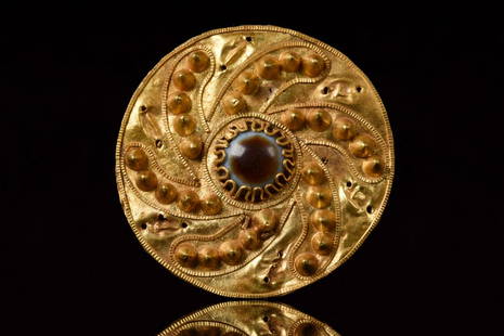 HELLENISTIC GOLD BROOCH WITH AGATE EYE: Ca. 300-100 BCHellenistic PeriodA finely rendered Greek Hellenistic gold disc-shaped brooch/pendant, hammered from thin gold, with an agate eye to the centre, along the brooch the front six rows of