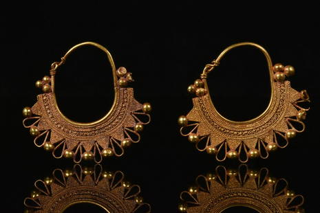 GREEK GOLD FILIGREE EARRINGS: Ca. 323-31 BCHellenistic PeriodA pair of beautiful gold earrings, each comprising an oval-shaped hoop with hooked attachment and a semi-circular filigree design, ornamented with spherical baubles,